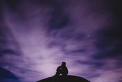 Silhouette of Sitting Man on a Hill Watching the Night Sky