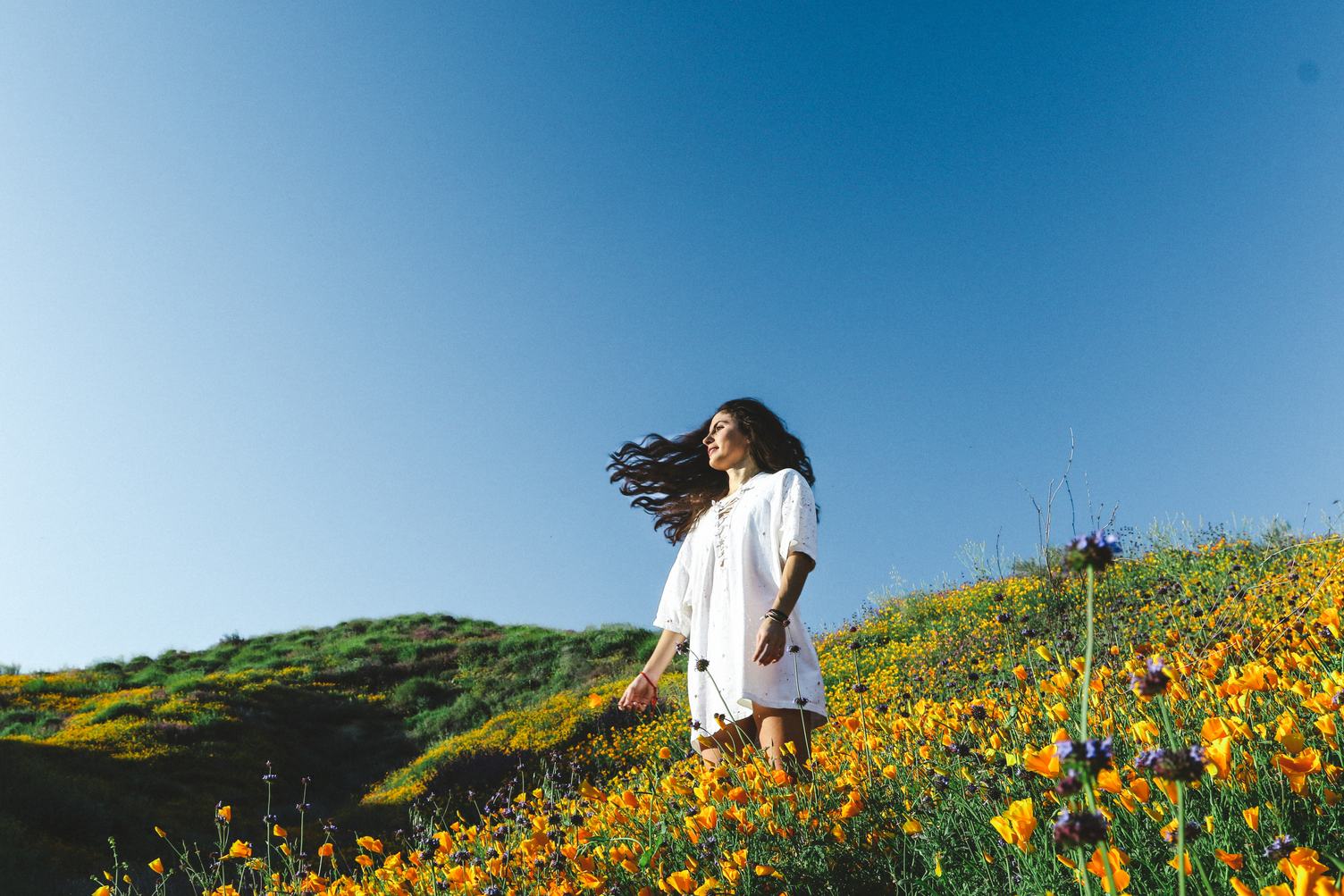 Woman at Blooming Orange Poppy Field
