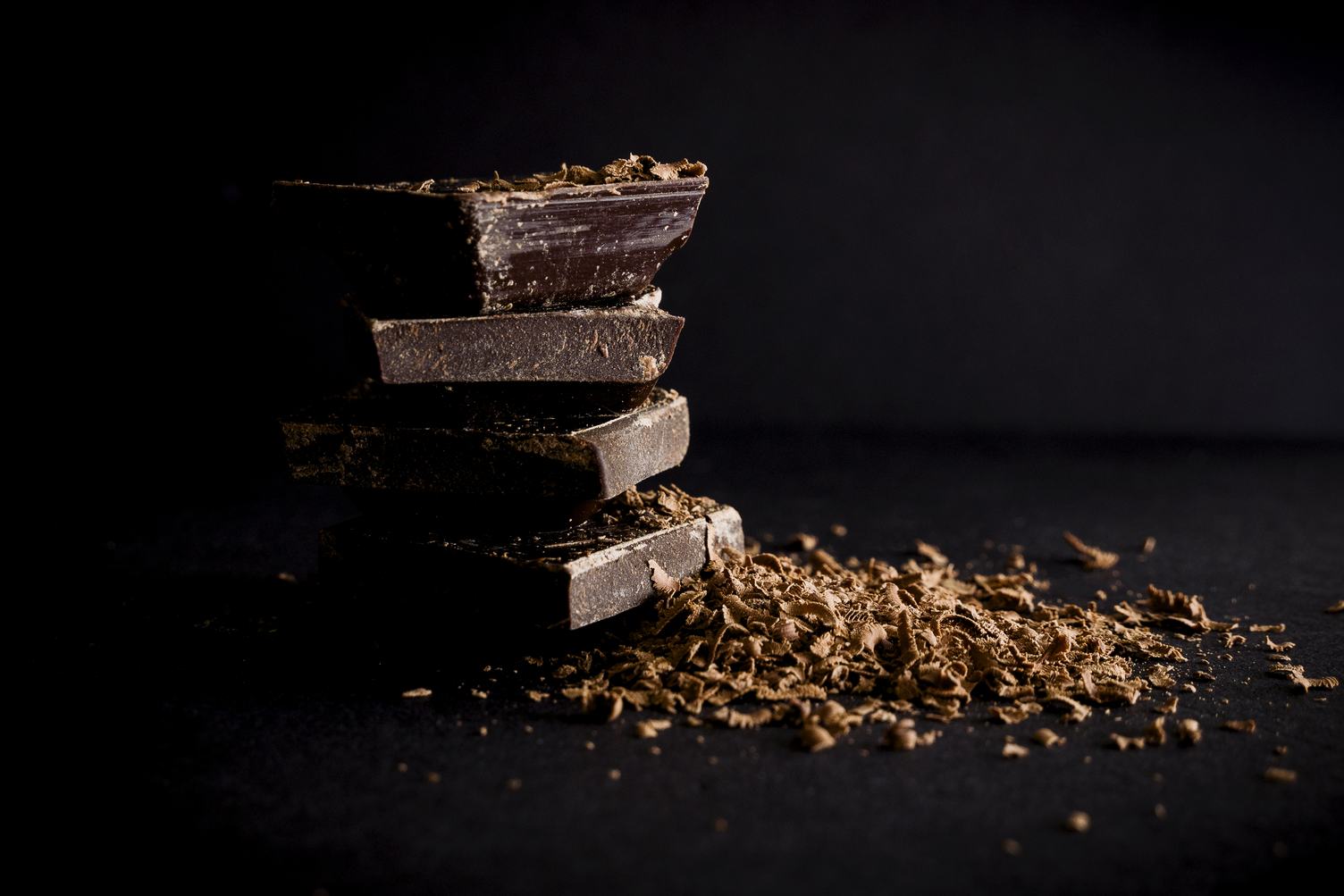 Dark Chocolate Stack and Chips on Black Background