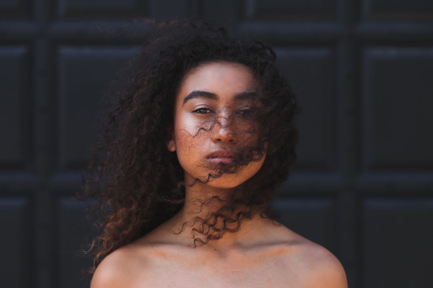 Woman with Brown Long Curly Hair and Naked Shoulders