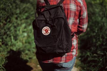 Person in Red checkered Shirt with Black Backpack Walking