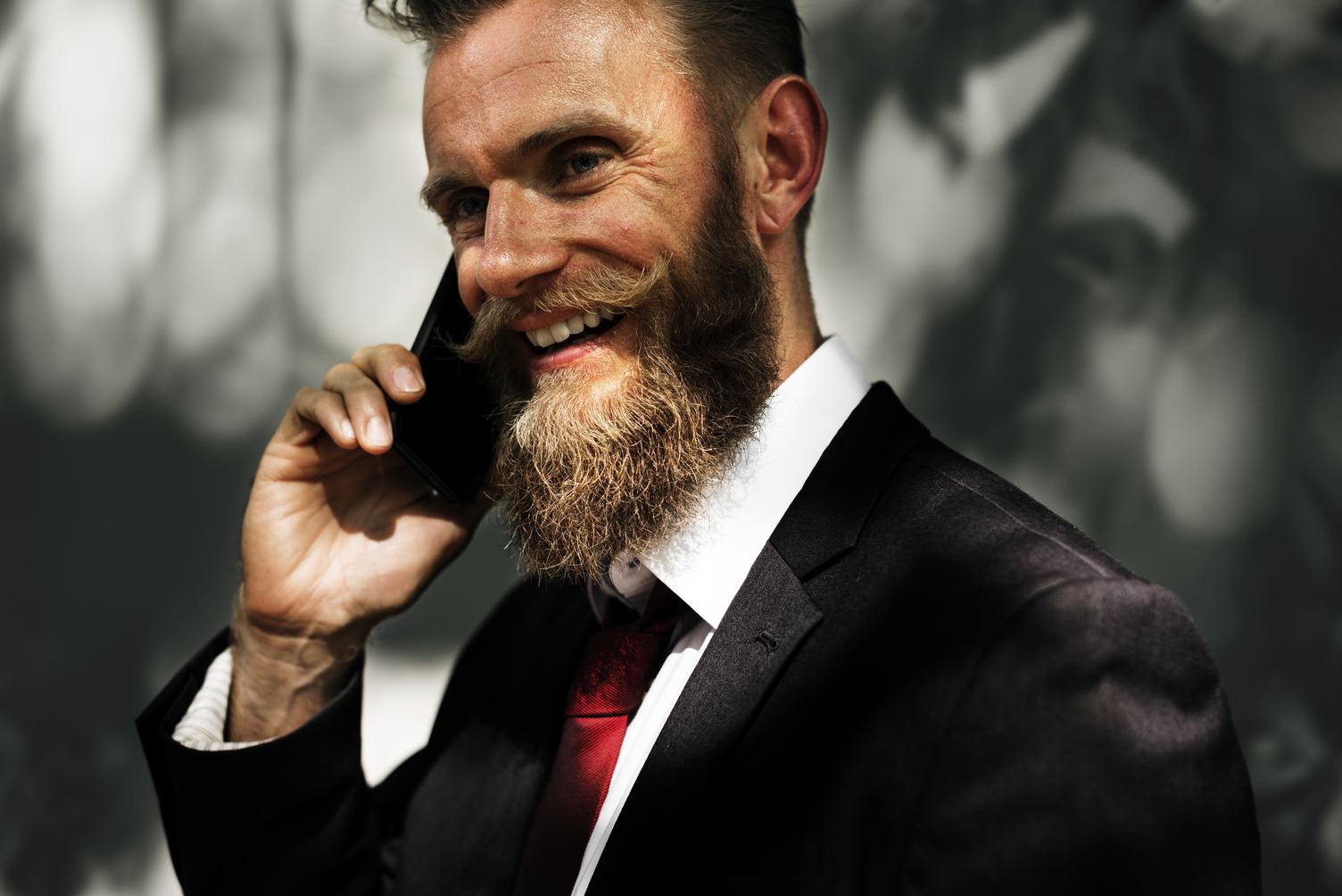 Happy Man Wearing Elegant Black Suit Talking on the Phone