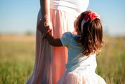 Pregnant Woman with her Baby Daughter in a Meadow