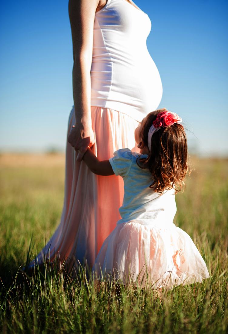 Pregnant Woman with her Baby Daughter in a Meadow