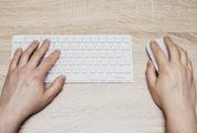 Man Typing on White Keyboard