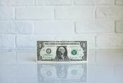 One Dollar Banknote against White Brick Wall