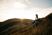 Young Couple Kissing on the Rock at Sunset