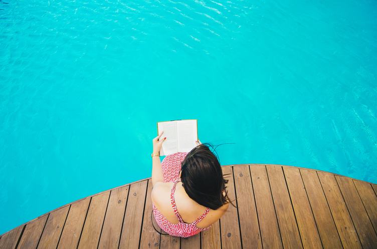 Top View of Woman Sitting on a Pier and Reading