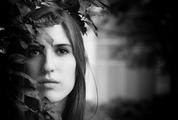 Black and White Portrait of a Beautiful Young Woman Hidden in the Leaves