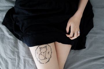 Top View of Woman with Artistic Paint Fox Tattoo on Her Leg Closeup on Body Art