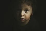 Face of Little Boy Emerging from Darkness