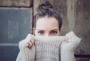 Young Woman Face Hidden behind Sweater