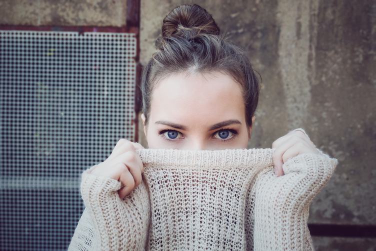 Young Woman Face Hidden behind Sweater