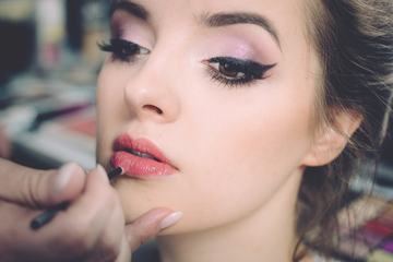 Makeup Artist Applies Lipstick Beautiful Woman Face. Perfect Makeup