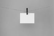 White Paper Card Hanging on the Rope on Gray Background