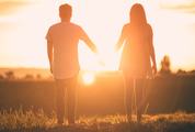 Young Couple Enjoying the Sunset Holding Hands
