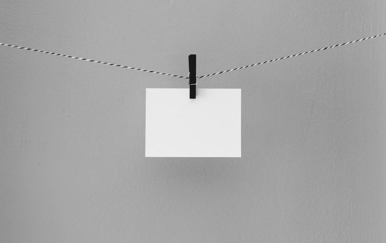 White Paper Card Hanging on the Rope on Gray Background