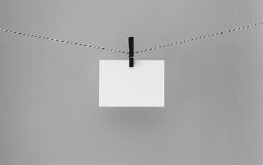 White Paper Card Hanging on the Rope on Gray Background