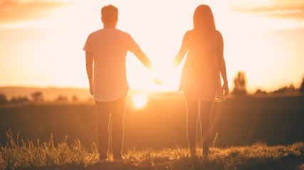 Young Couple Enjoying the Sunset Holding Hands