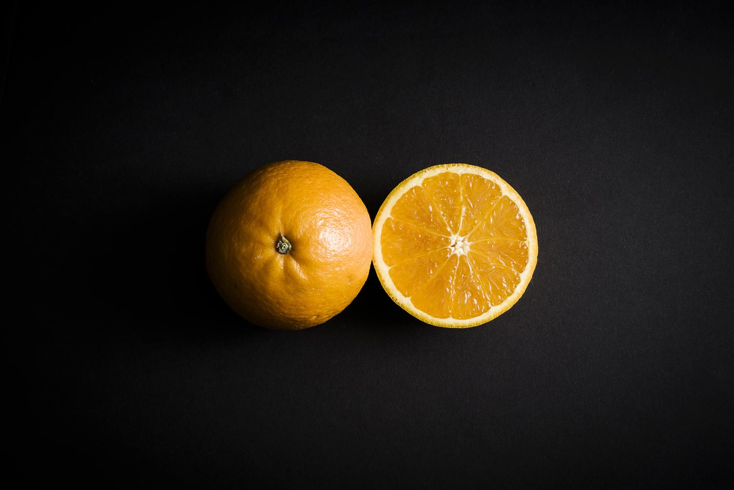 Orange Fruit Cut in Half on Black