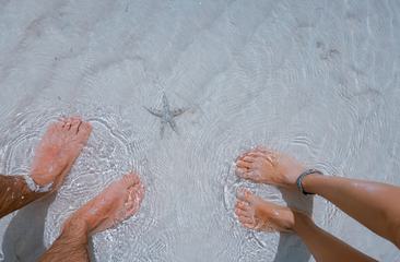 Woman's and Man's Legs Standing in Shallow