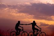 Couple Stretching Arms to each other While Riding Bicycles