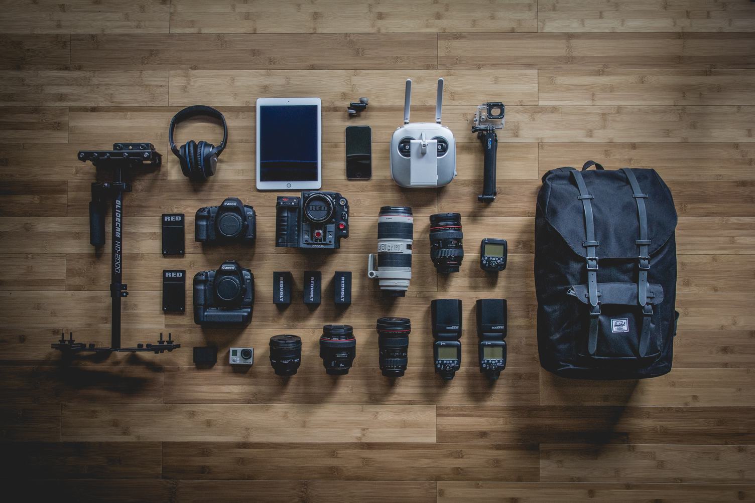 Diverse Personal Photographer Equipment Laying on the Wooden Floor