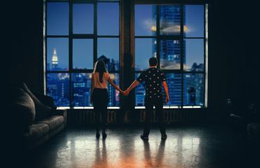 Couple Looking Out of Window in Luxary Apartment