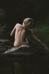 Back View of Nude Woman Sitting on the Rock