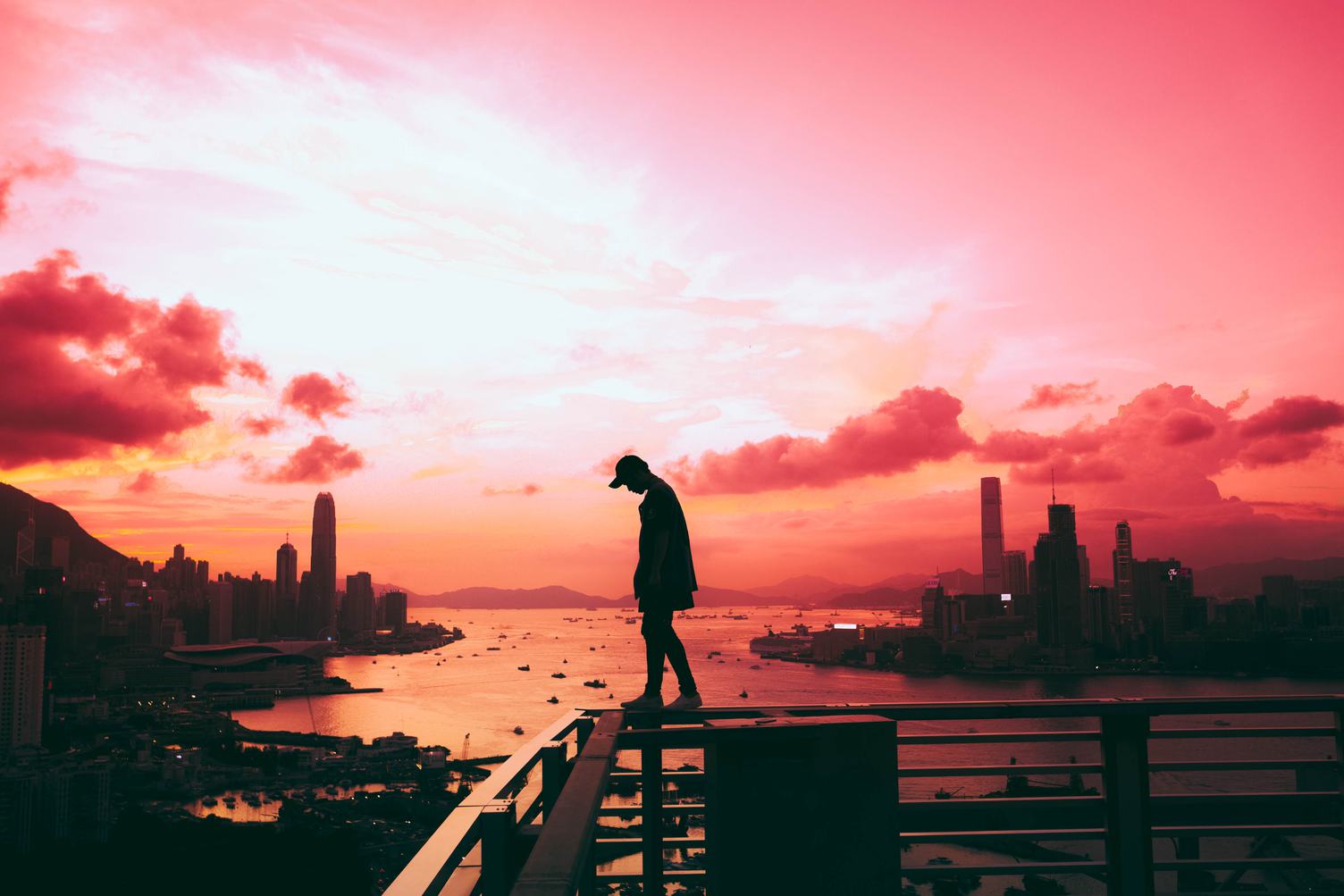 Man walking on the Railing, Victoria Harbor at Sunset, Hong Kong