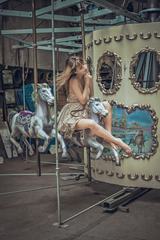 Young Woman Posing on Carousel in Pretty Summer Dress
