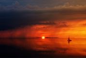 Sailboat Sunset against a Vivid Colorful Sunset with Clouds