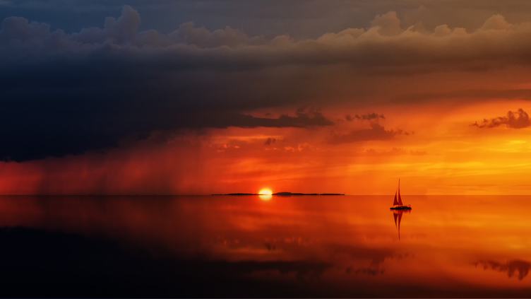 Sailboat Sunset against a Vivid Colorful Sunset with Clouds