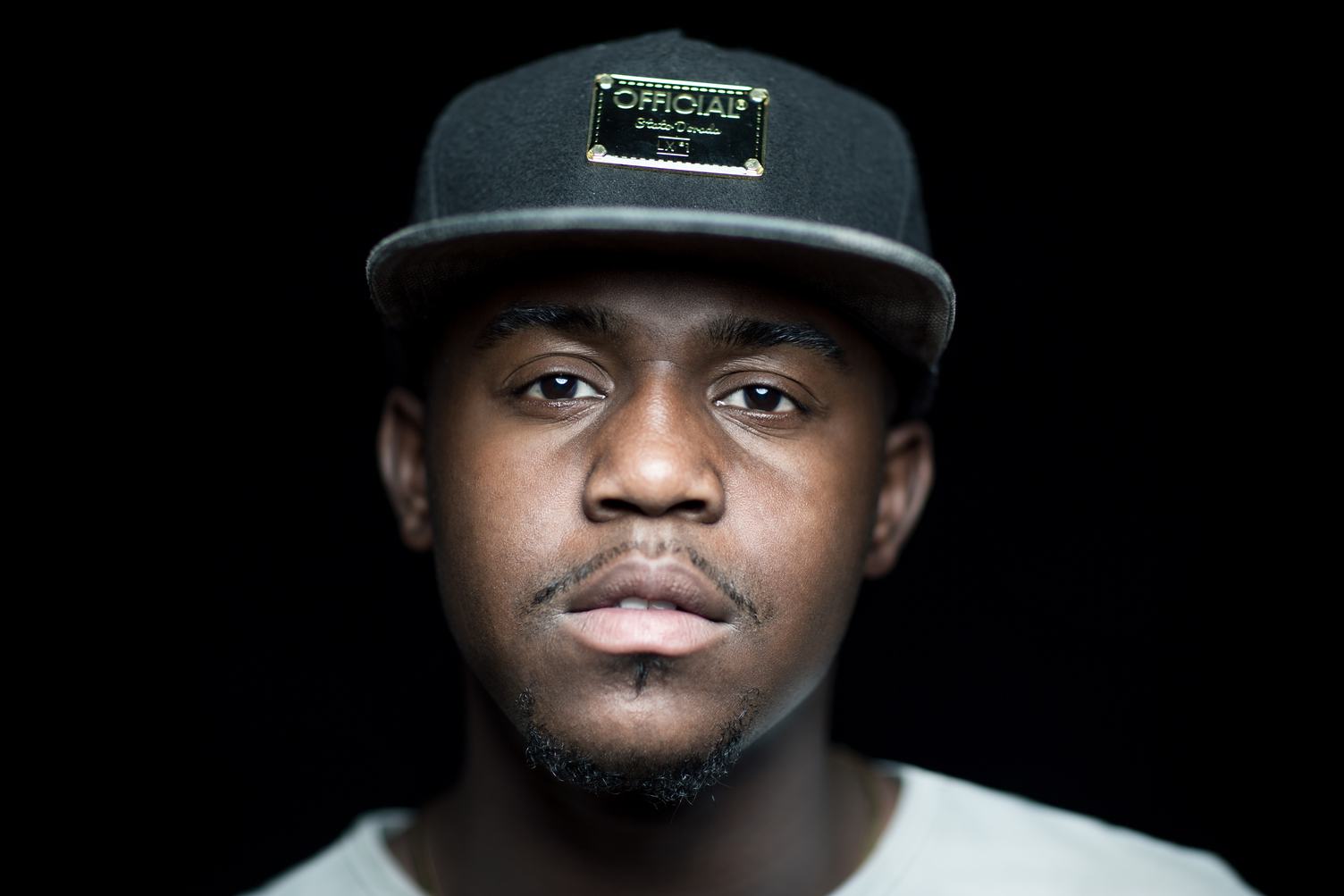 Portrait of Young Man with Cap On Black Background