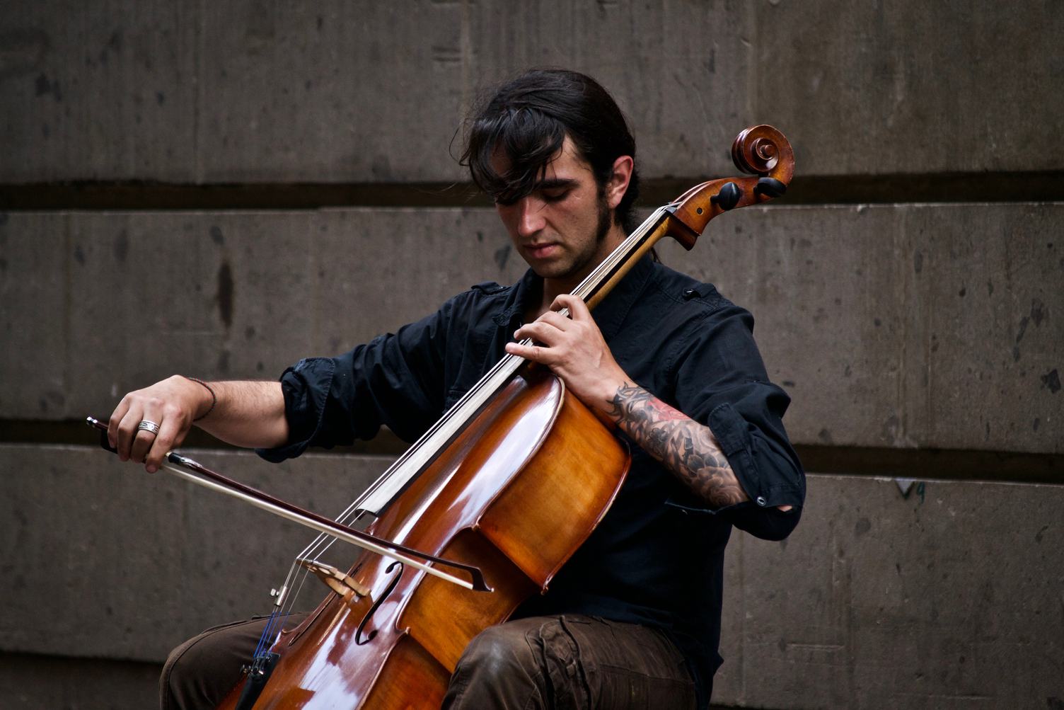Man with Tattoo Playing Cello Outdoors