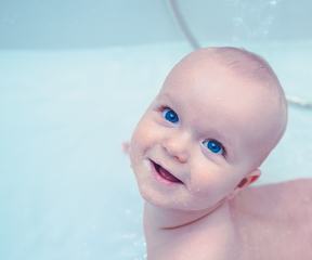 Lttle Baby Boy with Incredible Blue Eyes during the Bath