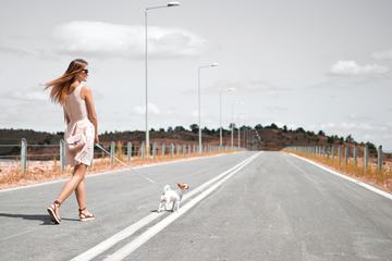 Beautiful Woman Walking with Her Dog on an Empty Road