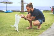 Bearded Guy Holding Little White Puppy Outdoors