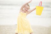 Girl in Yellow Dress Having Fun Playing on a Beach with Bucket