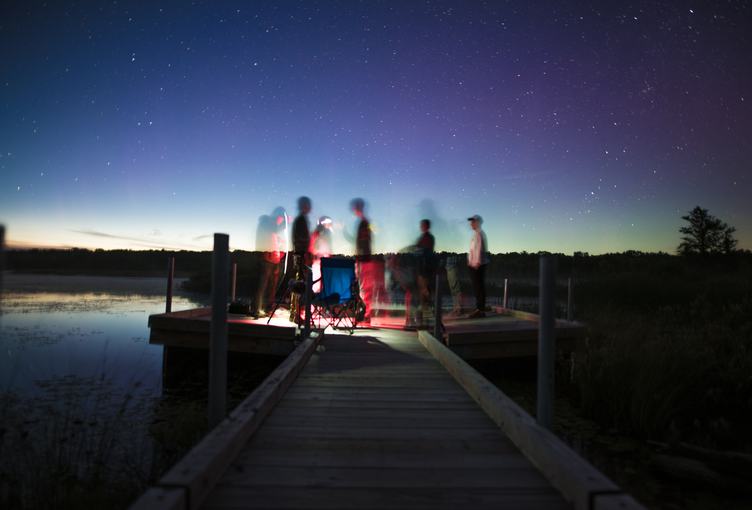 Group of Friends on a Pier by the Lake at Night