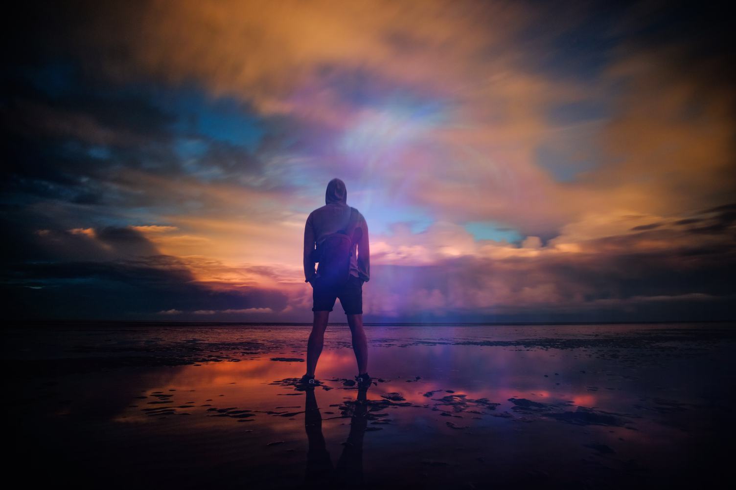 Man Standing behind the Background of a Stunning Sunset