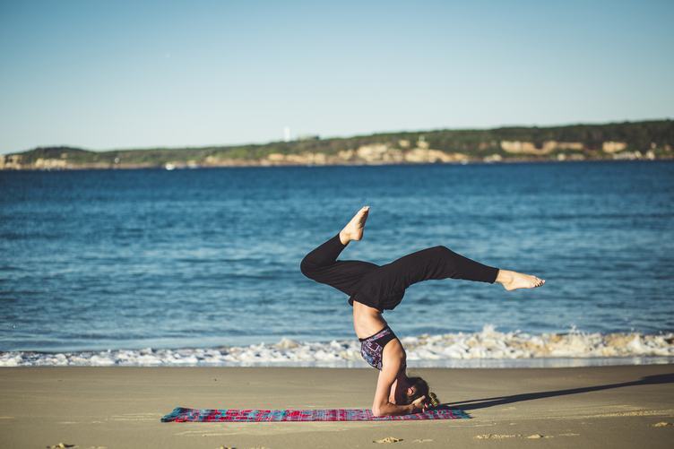Young Woman Does Yoga on the Beach