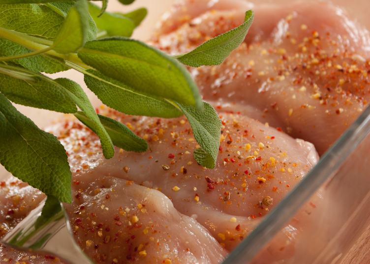 Raw Chicken Breasts Seasoned with Sage Leaves