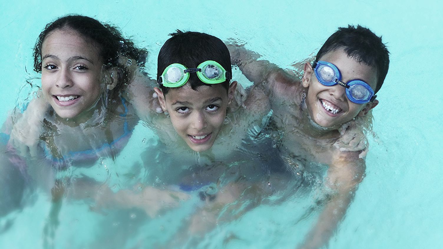 Two Boys and a Girl Playing In the Swimming Pool