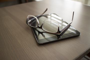 iPad and Glasses on Wooden Table