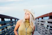 Young Blonde Girl with Cowboy Hat on the Bridge