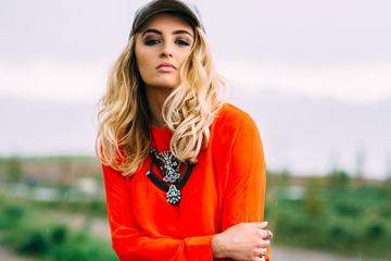 Blonde Wearing Orange Blouse, Necklace and Hat