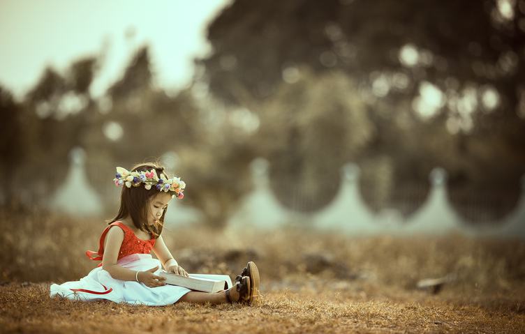 Asian Little Girl Sitting with a Book