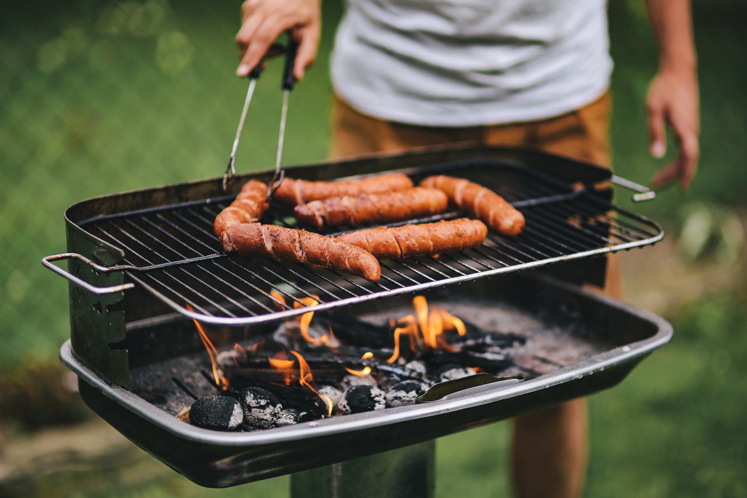 Man Grilling Sausages Outdoors