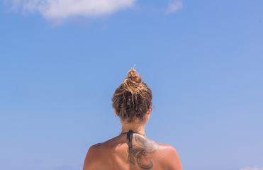 Tanned Woman's Back against the Blue Sky